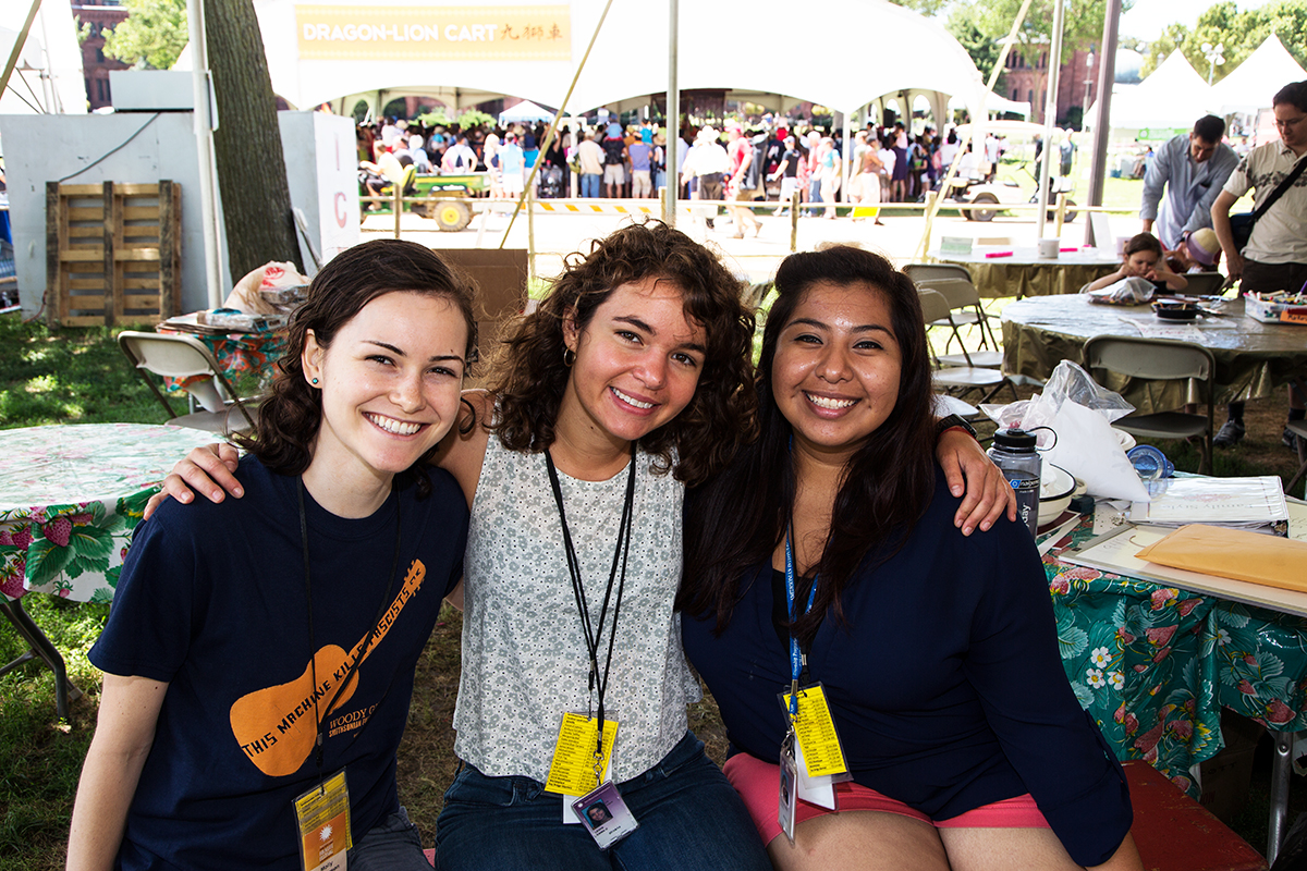 Interns Molly Henderson, Emma Lewis, and Julia Aguilar in the Family Style tent at the 2014 Folklife Festival.